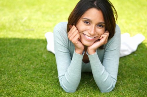 image of smiling woman laying on the grass