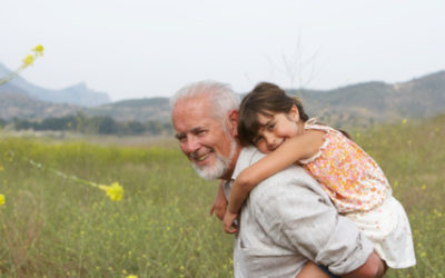 image of older man giving a little girl piggy back ride