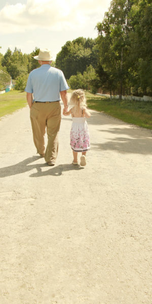 image of older man and young girl walking and holding hands